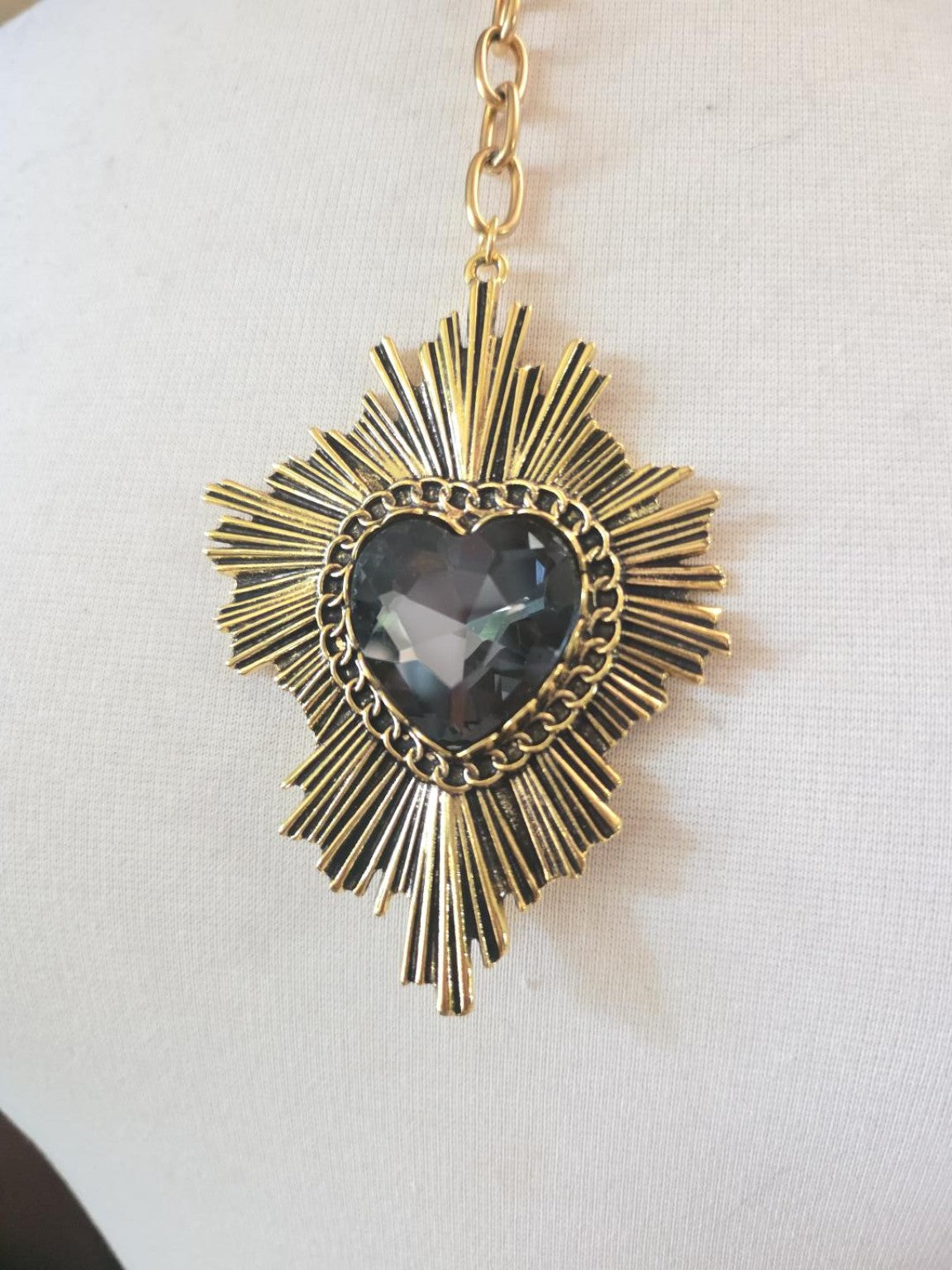 Gold-plated sunburst necklace with faceted black heart