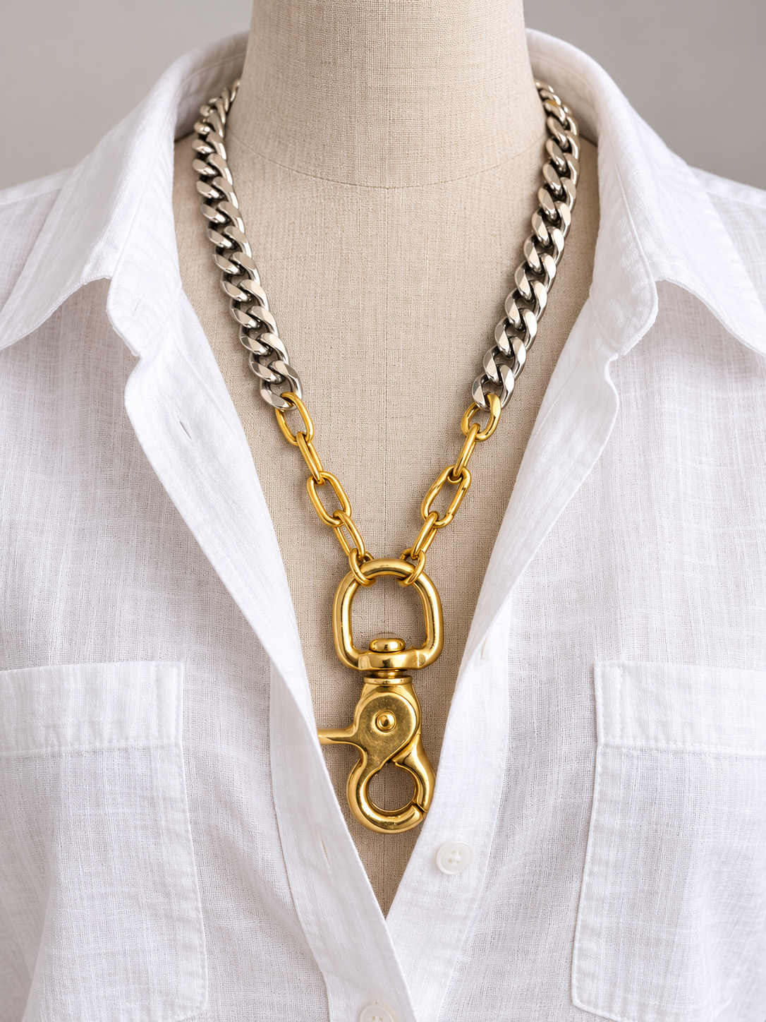 Mixed-Metal Clasp Necklace styled on a white linen shirt mannequin