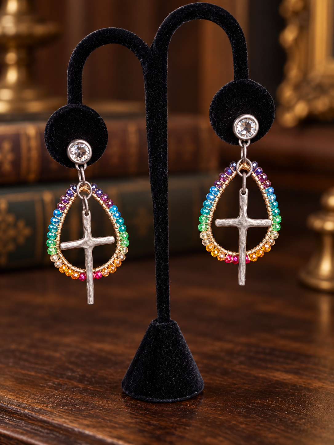 Rainbow cross beaded earrings on black velvet display