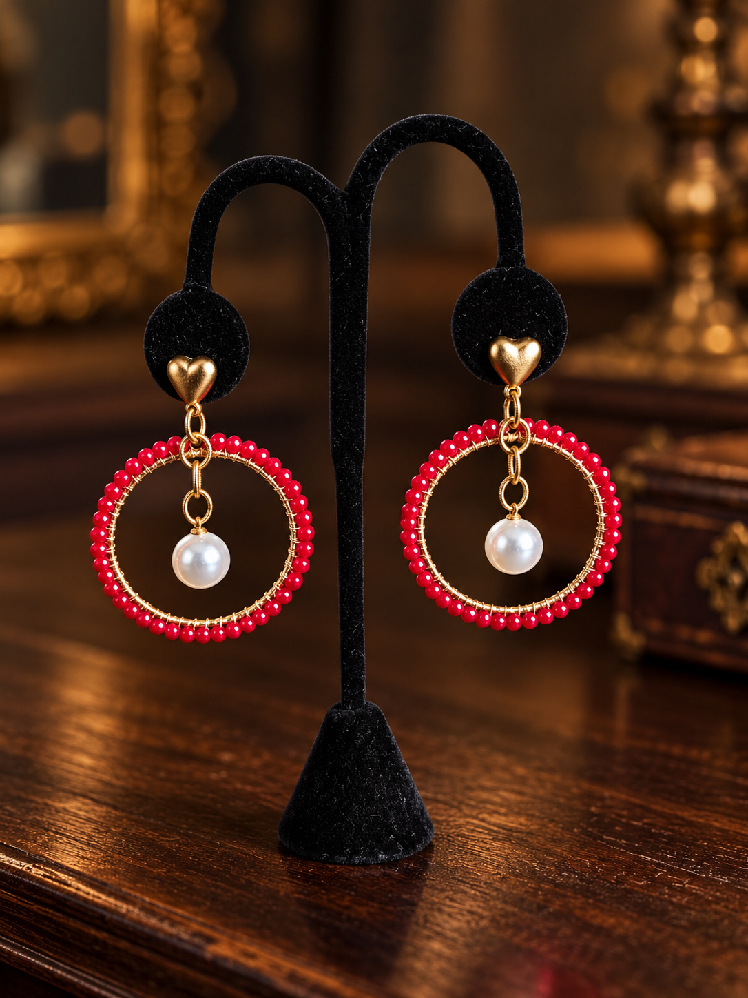 Red beaded pearl hoop earrings on black velvet display