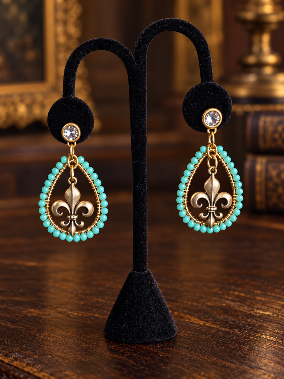 Turquoise fleur-de-lis beaded earrings on black velvet display